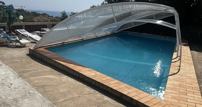 abri de piscine bas amovible avec ouverture latérale permettant la baignade sous abri dans le Var