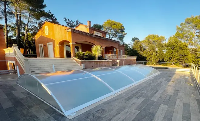 Abri de piscine bas relevable et amovible Atoll installé sur une terrasse de villa dans le Var avec ouverture sans rail