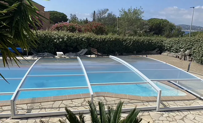 Abri de piscine bas télescopique sans rail avec modules coulissants permettant l’ouverture du bassin, installation dans le Var
