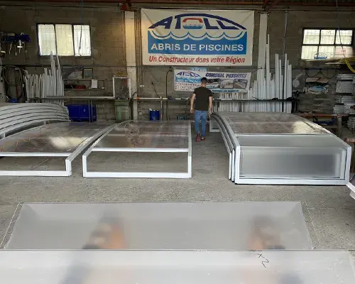 Atelier de fabrication d’abris de piscine Atoll dans le Var avec structures aluminium en cours de montage