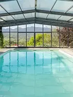 Abri de piscine haut lumineux avec grandes surfaces vitrées dans le Var